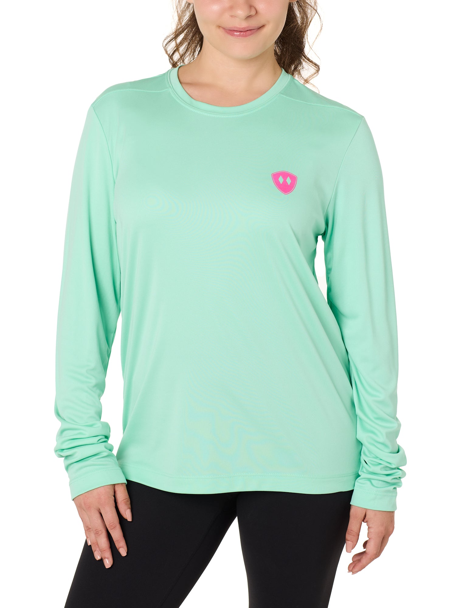 Front view of a female model wearing the Surfer Skeleton performance long sleeve tee in mint green on a white background. Accented with a hot pink double diamond shield over wearers left chest.