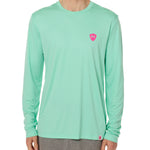 Front view of a male model wearing the Surfer Skeleton performance long sleeve tee in mint green on a white background. Accented with a hot pink double diamond shield over wearers left chest.