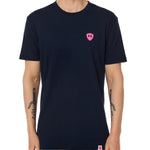 Front view of a male model wearing the Skull Wave Head crew neck tee in Navy on a white background. Accented with a hot pink double diamond shield over wearers left chest.