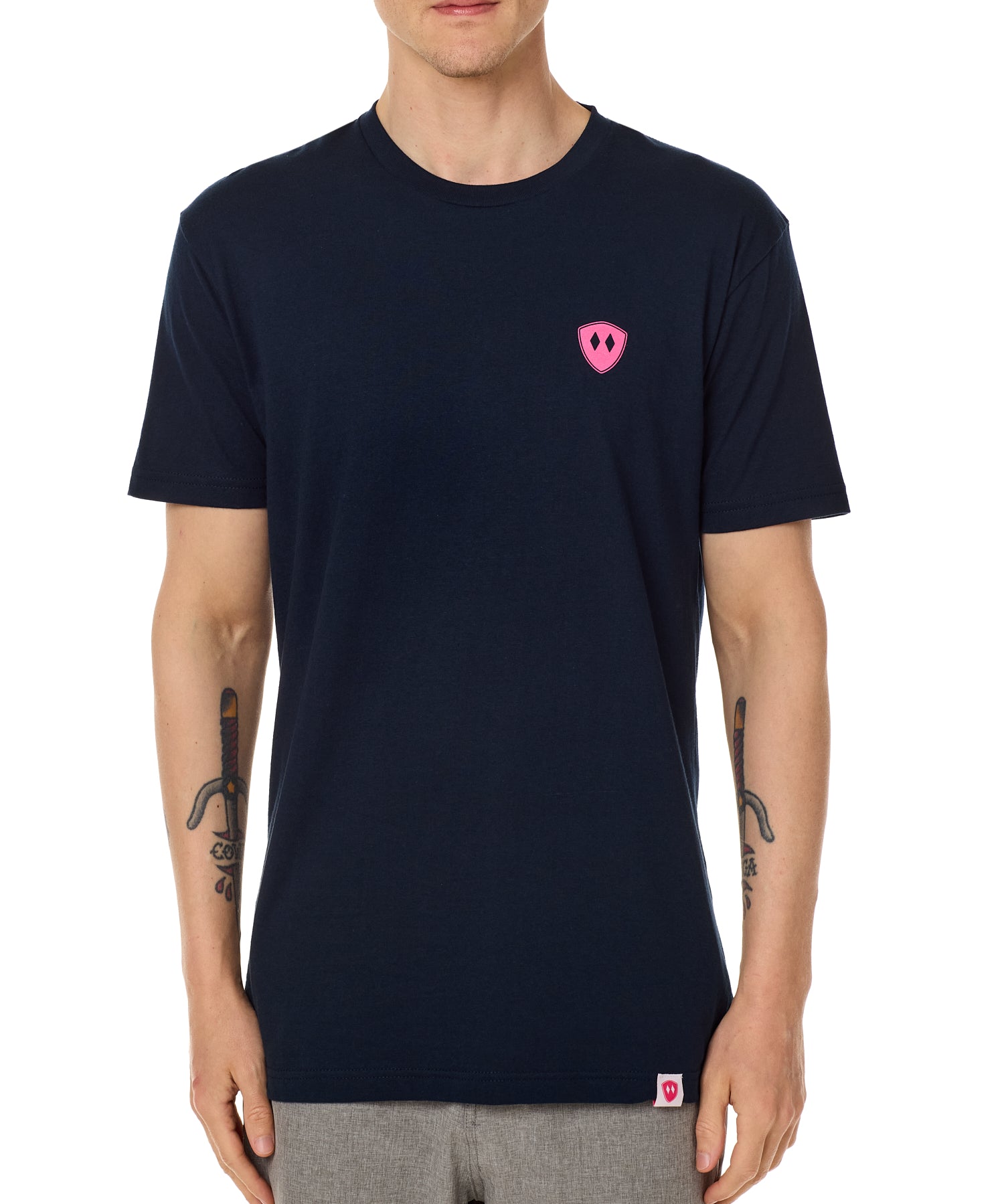 Front view of a male model wearing the Skull Wave Head crew neck tee in Navy on a white background. Accented with a hot pink double diamond shield over wearers left chest.
