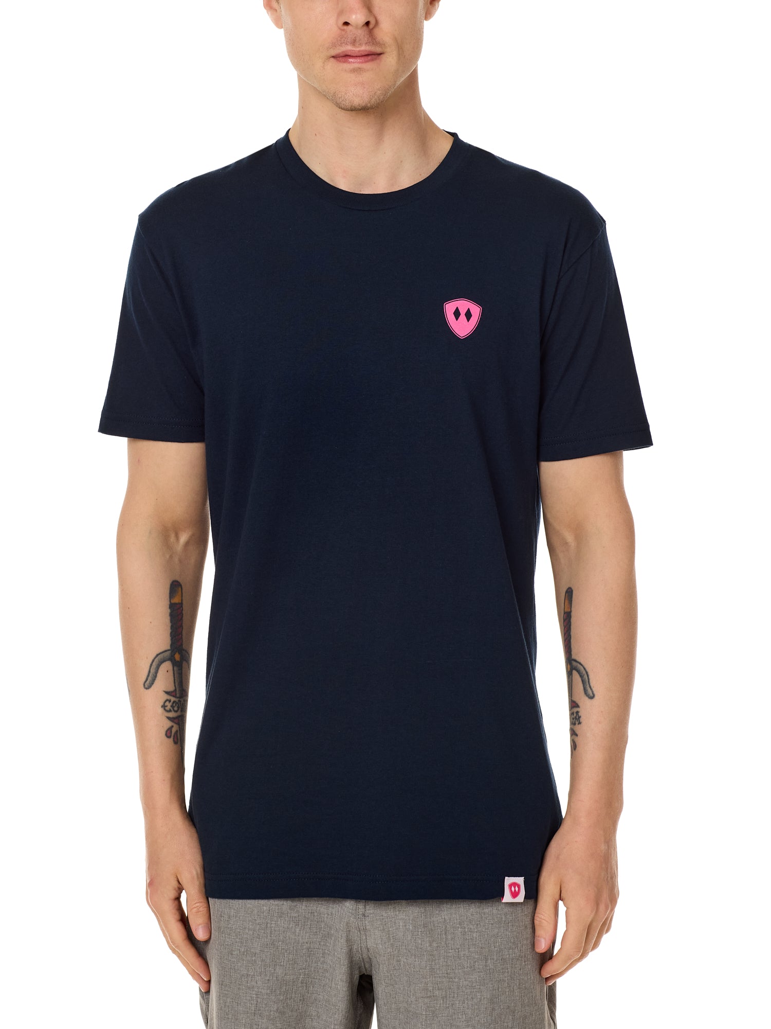 Front view of a male model wearing the Skull Wave Head crew neck tee in Navy on a white background. Accented with a hot pink double diamond shield over wearers left chest.