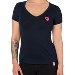 Front view of a female model wearing the Skull Wave Head V neck tee in mint green on a white background. Accented with a hot pink double diamond shield over wearers left chest.