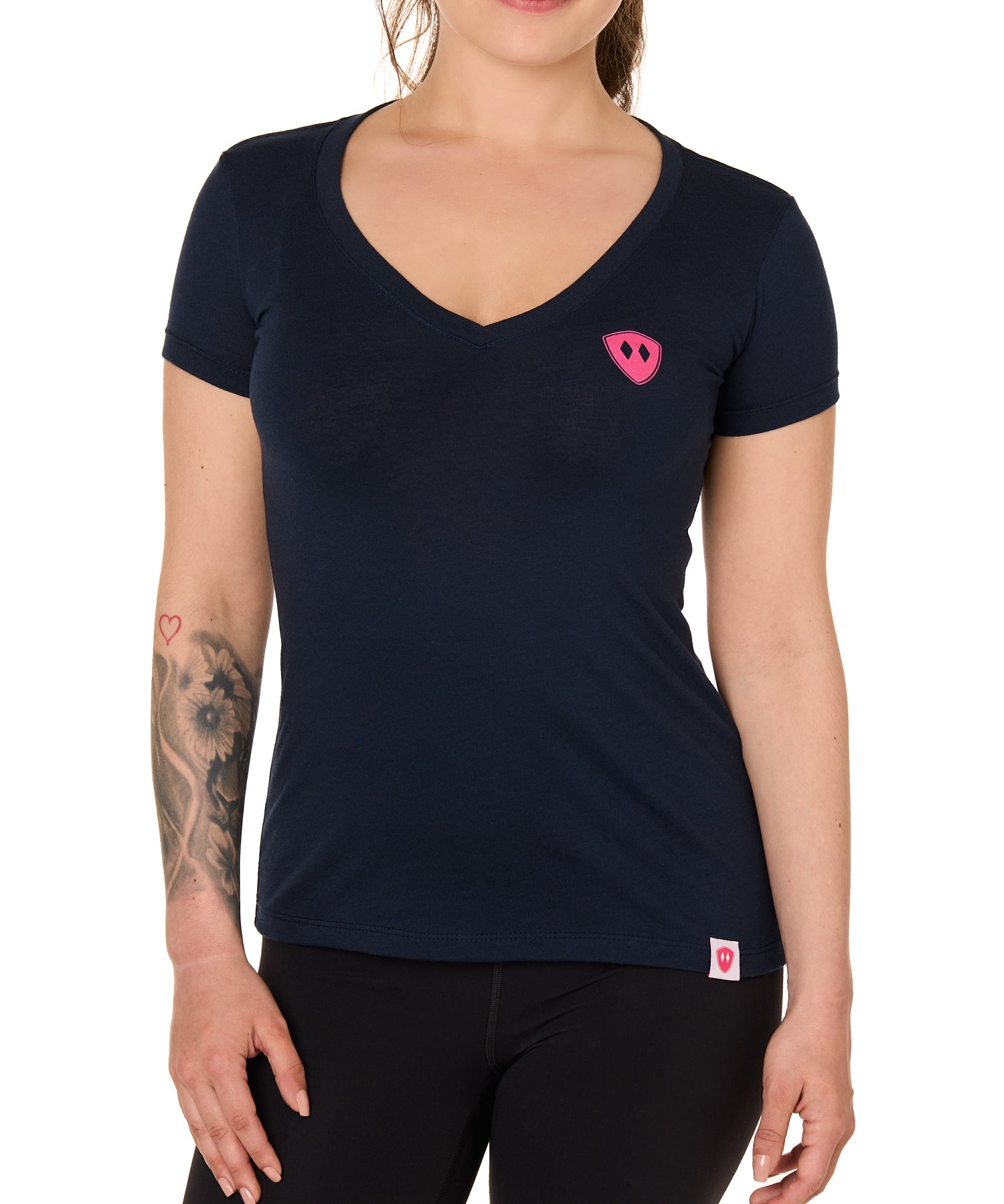 Front view of a female model wearing the Skull Wave Head V neck tee in mint green on a white background. Accented with a hot pink double diamond shield over wearers left chest.