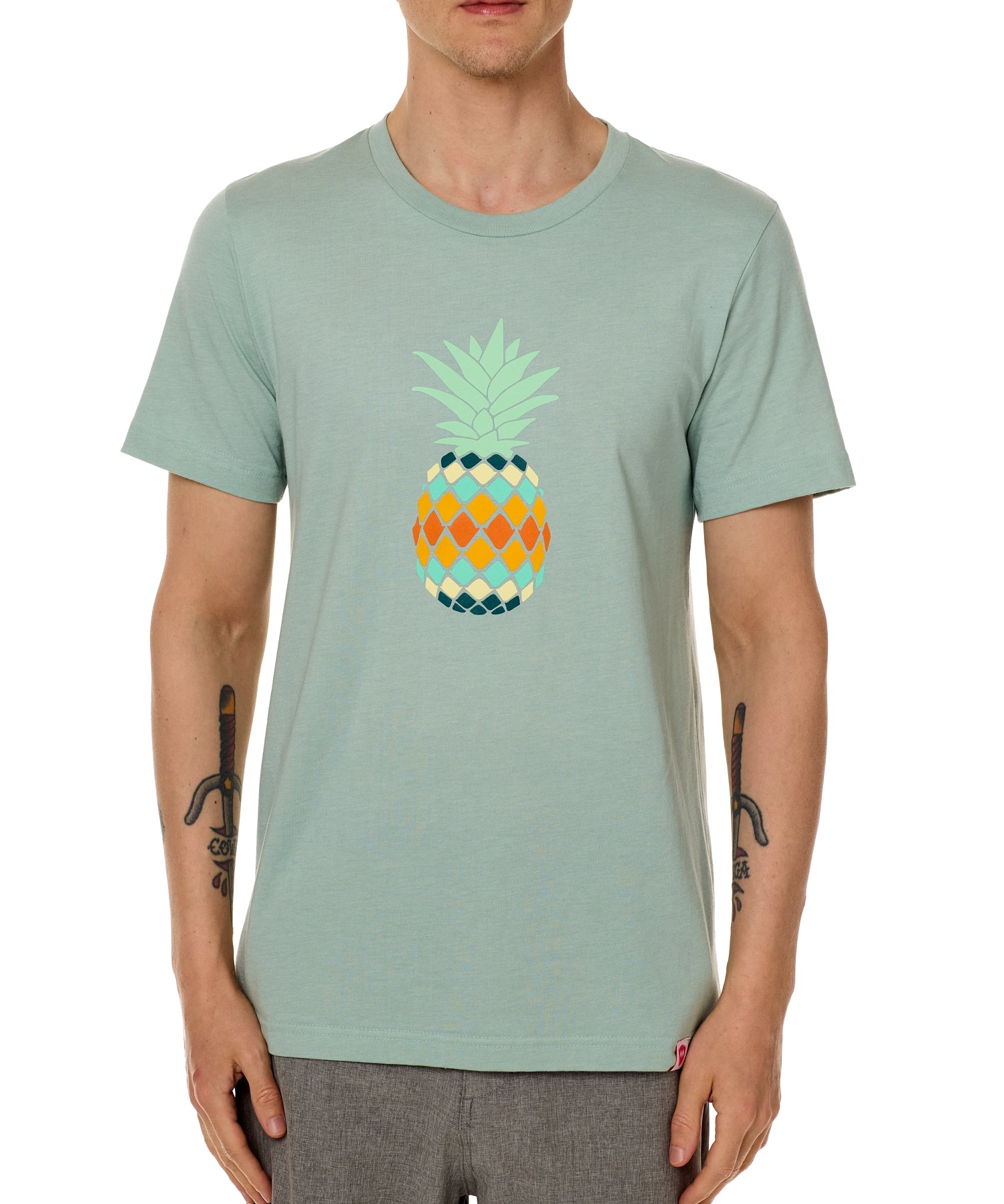 Front view of a male model wearing a dusty blue green short sleeve crew neck t-shirt with a vibrantly colored retro pineapple graphic on the front.