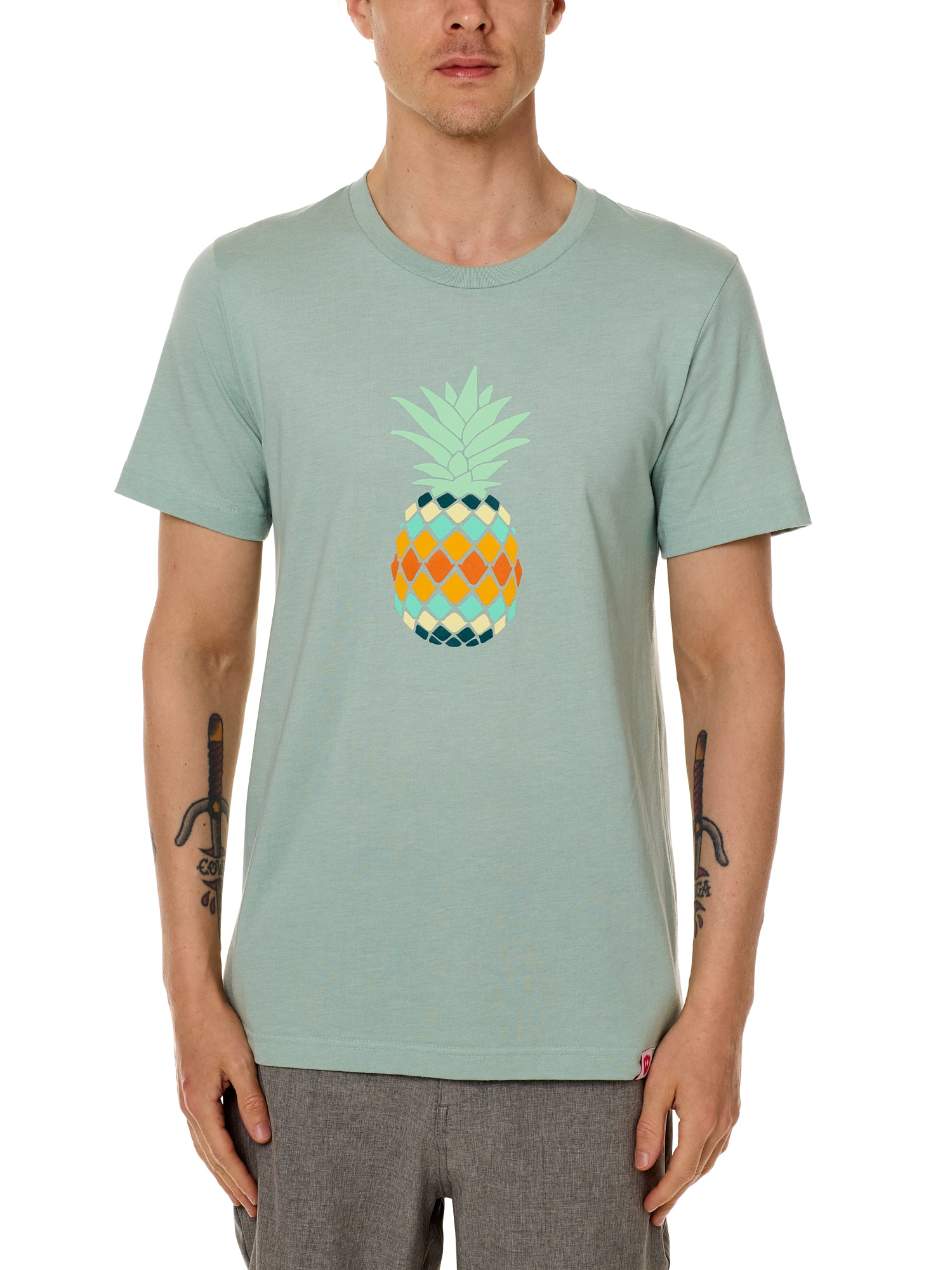 Front view of a male model wearing a dusty blue green short sleeve crew neck t-shirt with a vibrantly colored retro pineapple graphic on the front.