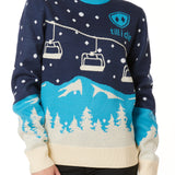 A woman wearing a navy and blue sweater with a snowy mountain and chairlift design.