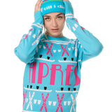 FEMALE MODEL WEARING A MATCHING TEAL AND PINK "APRES SKI" BEANIE AND SWEATER