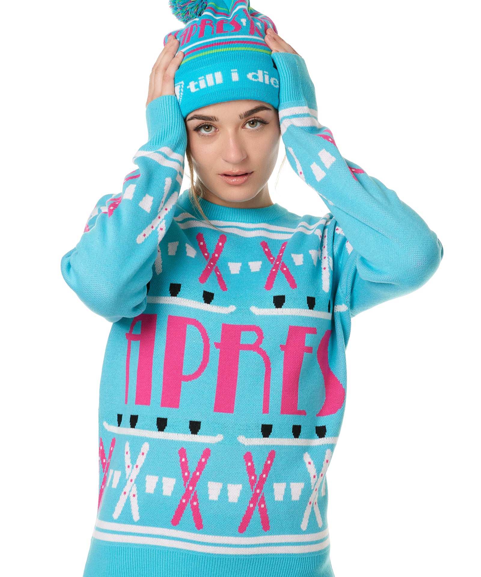 FEMALE MODEL WEARING A MATCHING TEAL AND PINK "APRES SKI" BEANIE AND SWEATER