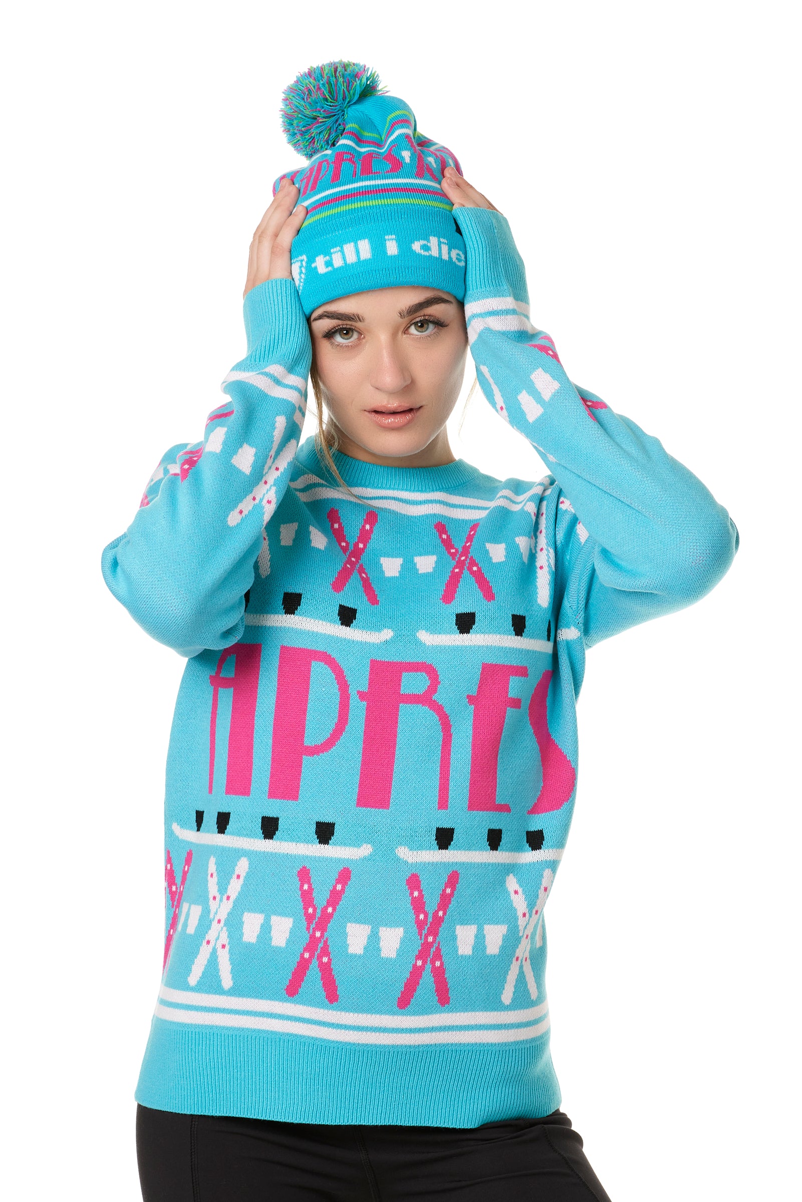 FEMALE MODEL WEARING A MATCHING TEAL AND PINK "APRES SKI" BEANIE AND SWEATER