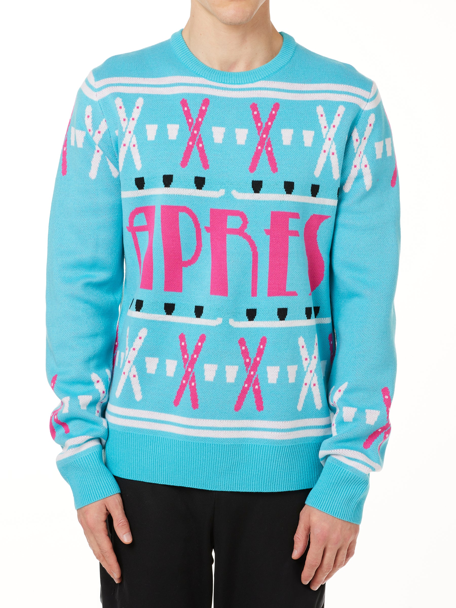 A male model wearing a TEAL AND PINK sweater with SHOT SKI GRAPHICS and the word 'APRES' written across the front.
