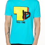 Front view of a male model wearing the TID TV crew neck tee in Tahiti Blue, displayed on a white background. The graphic features a large block-style yellow "T" alongside hand-drawn black "I" and "D" lettering, with "Till I Die" text beneath.