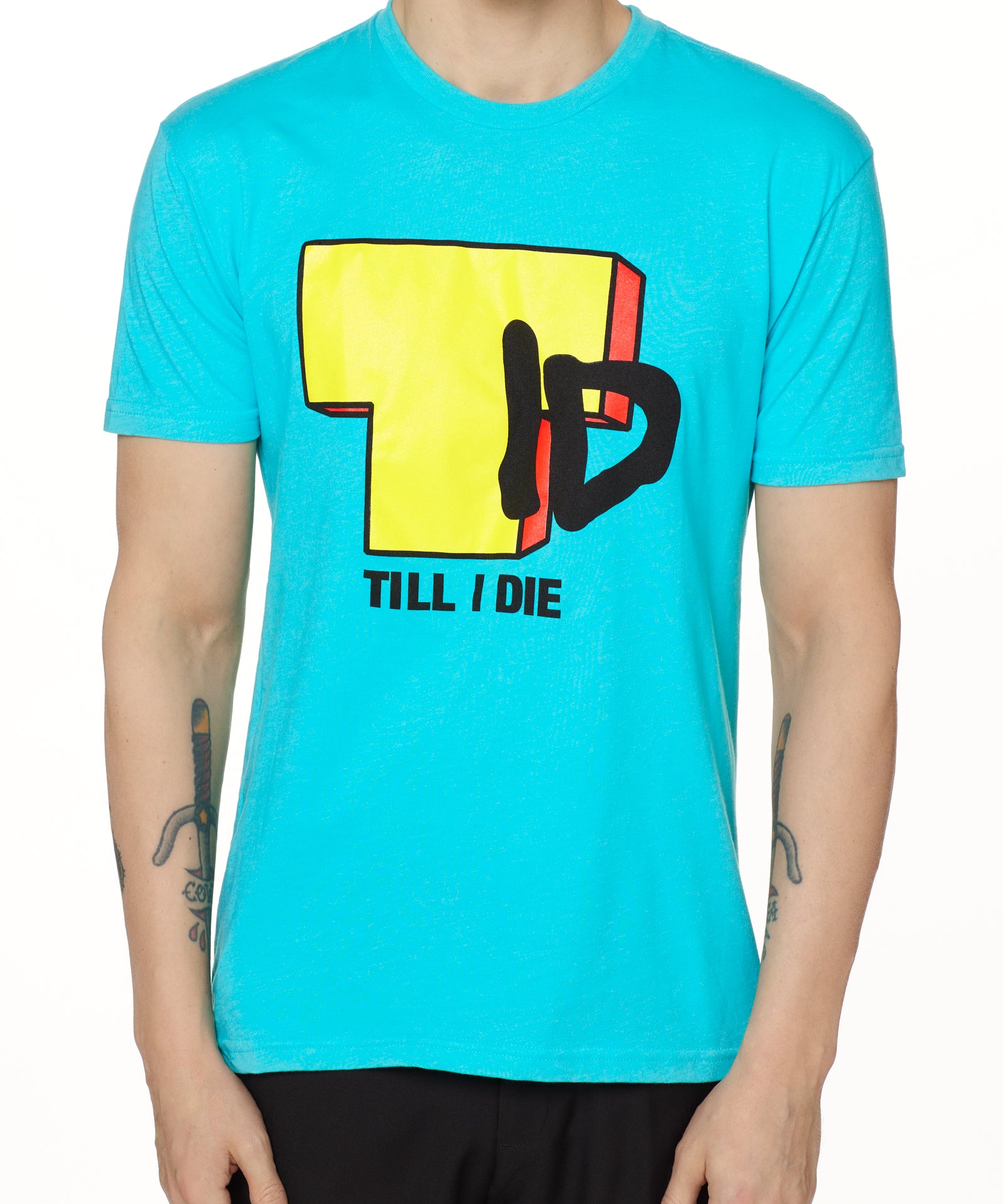 Front view of a male model wearing the TID TV crew neck tee in Tahiti Blue, displayed on a white background. The graphic features a large block-style yellow "T" alongside hand-drawn black "I" and "D" lettering, with "Till I Die" text beneath.