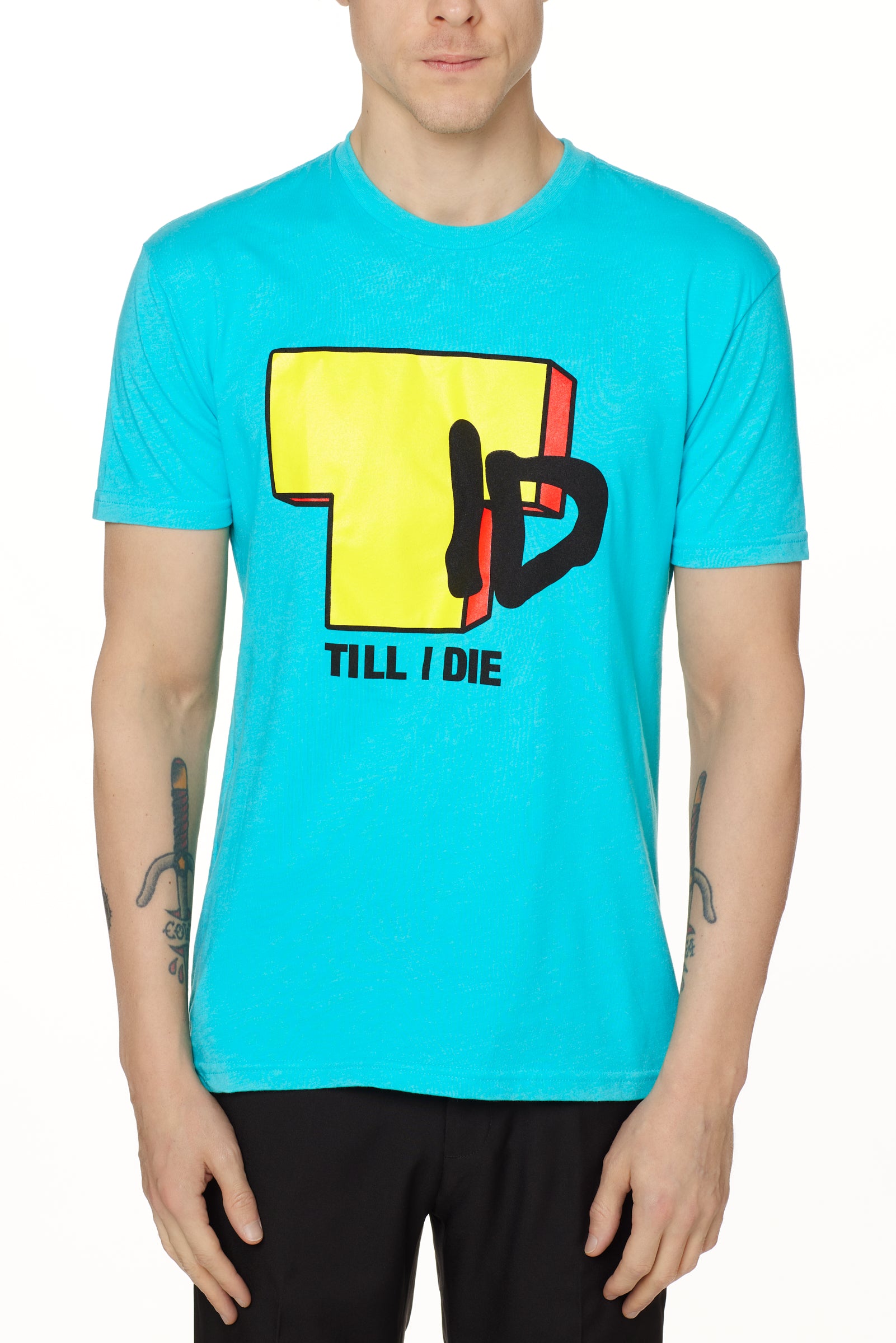 Front view of a male model wearing the TID TV crew neck tee in Tahiti Blue, displayed on a white background. The graphic features a large block-style yellow "T" alongside hand-drawn black "I" and "D" lettering, with "Till I Die" text beneath.