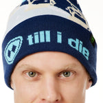 DETAIL OF A MALE MODEL WEARING A NAVY AND WHITE HAT WITH A BLUE POM POM AND CHAIRLIFT GRAPHIC WITH THE WORD "TILL I DIE" ON THE FOLD