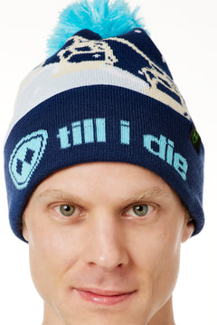 DETAIL OF A MALE MODEL WEARING A NAVY AND WHITE HAT WITH A BLUE POM POM AND CHAIRLIFT GRAPHIC WITH THE WORD "TILL I DIE" ON THE FOLD