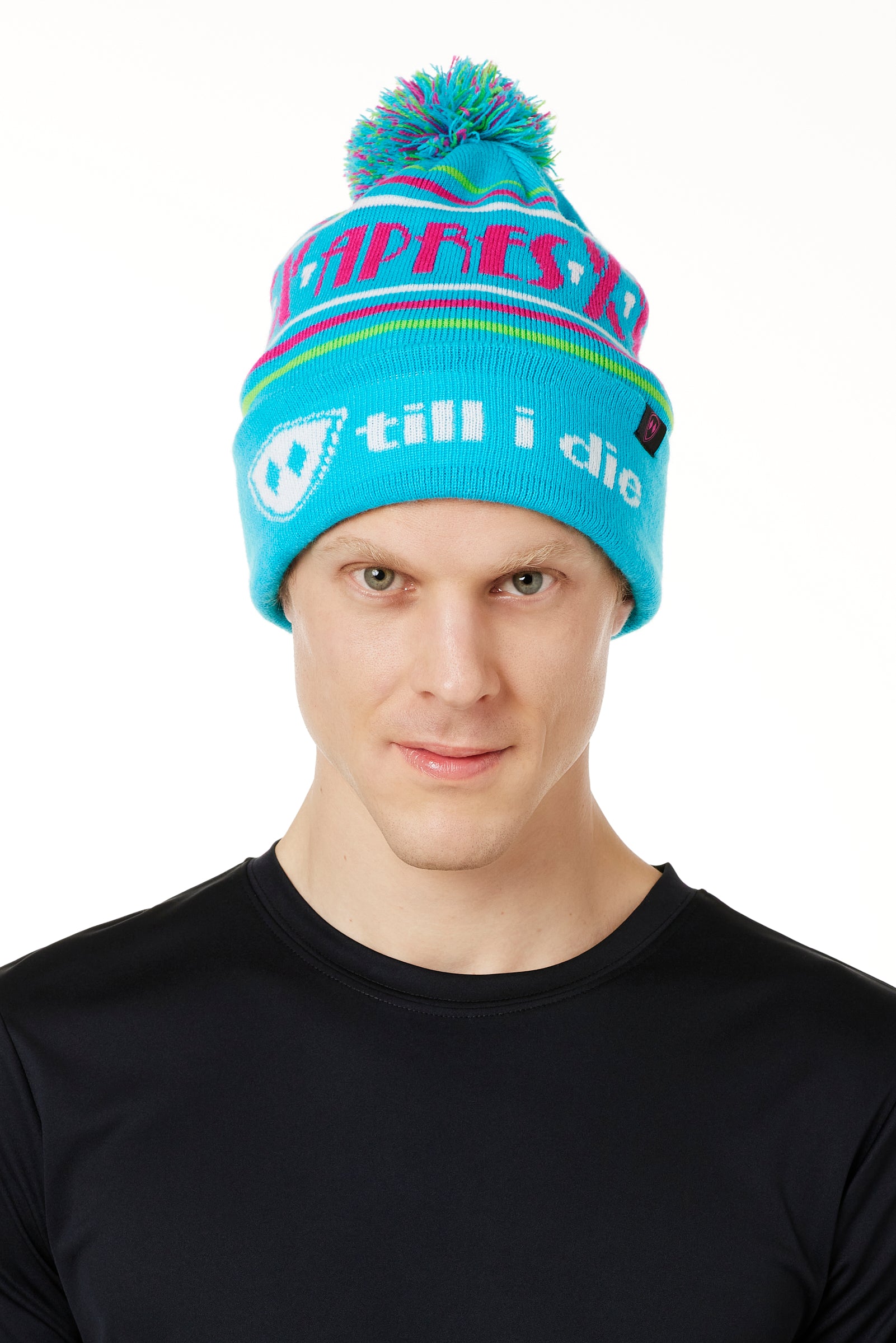 MALE MODEL WEARING A TEAL AND PINK HAT WITH A POM POM AND THE WORDS "APRES SKI"
