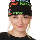 FEMALE MODEL WEARING A BLACK BEANIE WITH MULTICOLORED WORDS SAYING "DO WHAT YOU LOVE. DO IT FOREVER" 