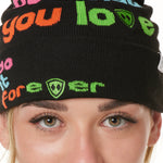 DETAIL OF A FEMALE MODEL WEARING A BLACK BEANIE WITH MULTICOLORED WORDS SAYING "DO WHAT YOU LOVE. DO IT FOREVER" 