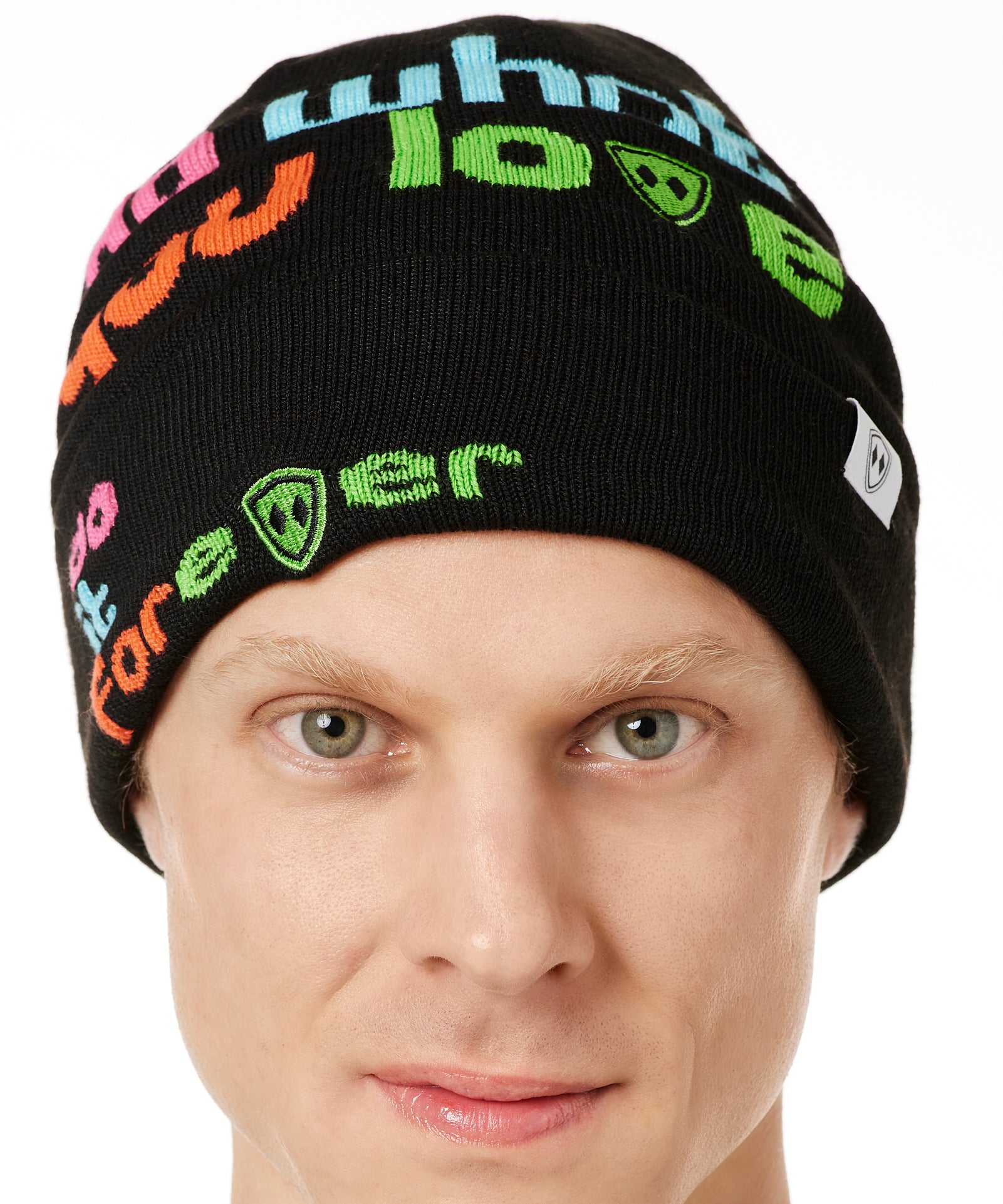 DETAIL OF A MALE MODEL WEARING A BLACK BEANIE WITH MULTICOLORED WORDS SAYING "DO WHAT YOU LOVE. DO IT FOREVER" 