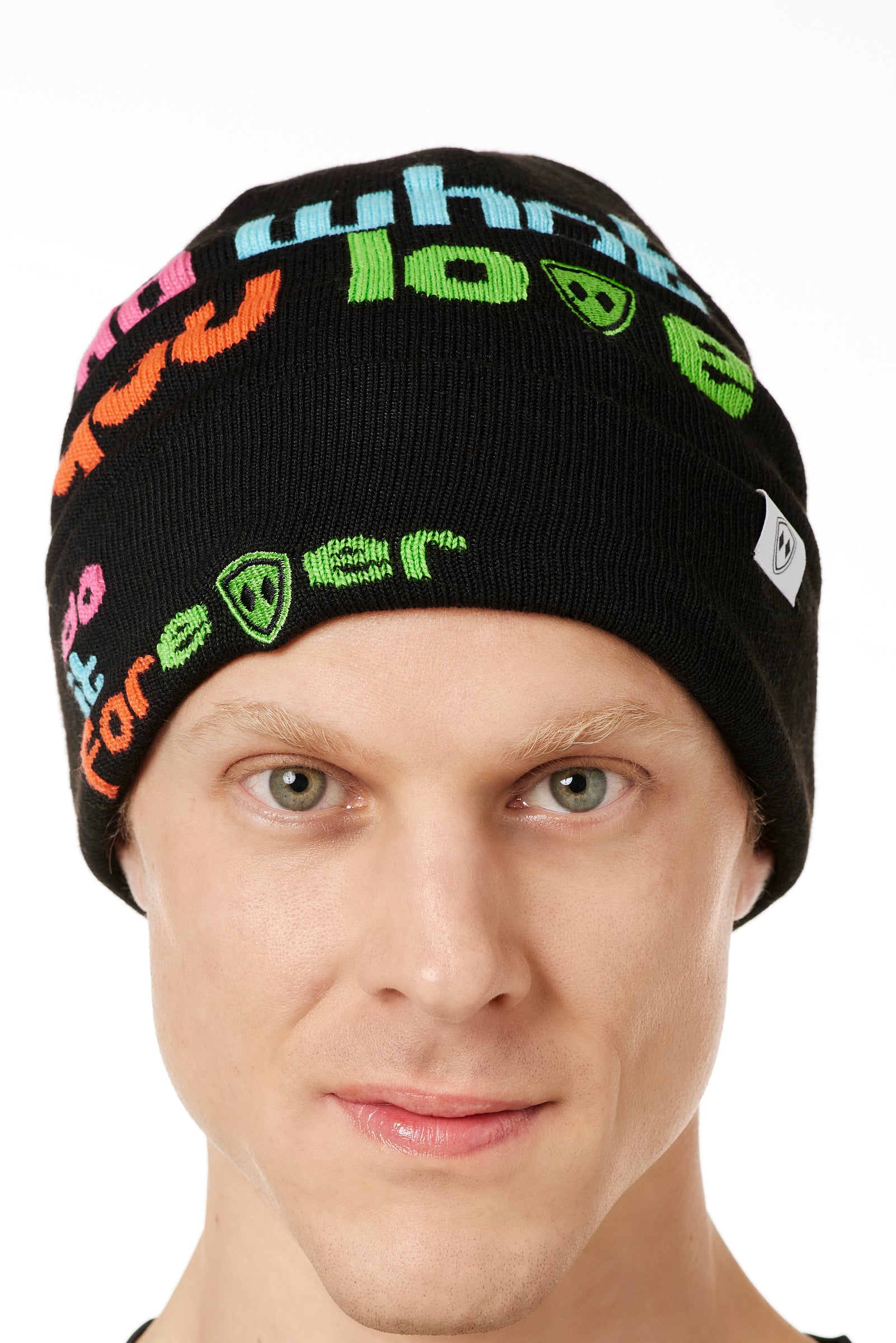 DETAIL OF A MALE MODEL WEARING A BLACK BEANIE WITH MULTICOLORED WORDS SAYING "DO WHAT YOU LOVE. DO IT FOREVER" 