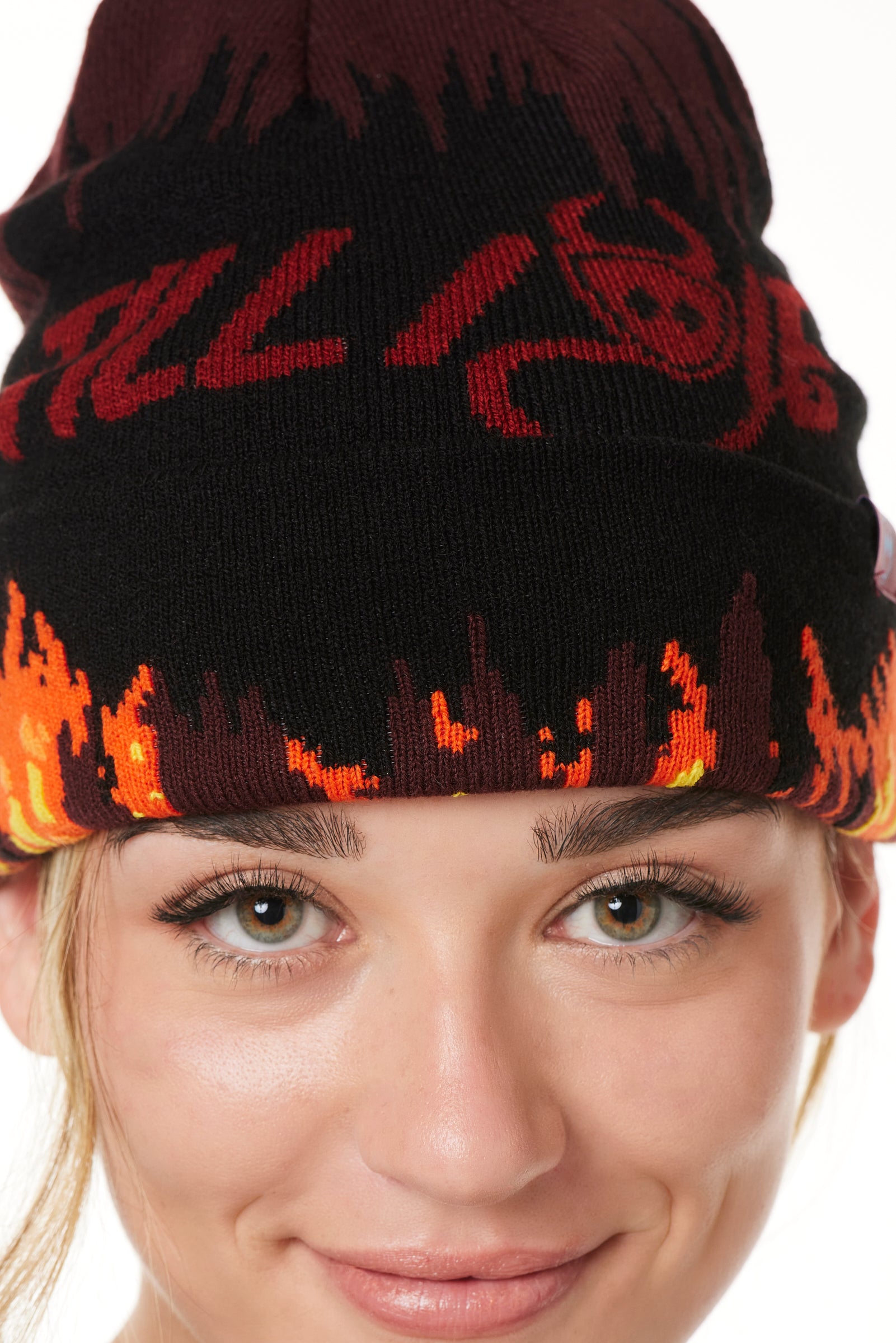 DETAIL OF A FEMALE MODEL WEARING A BEANIE HAT WITH FLAMES AND THE WORDS "TILL I DIE"