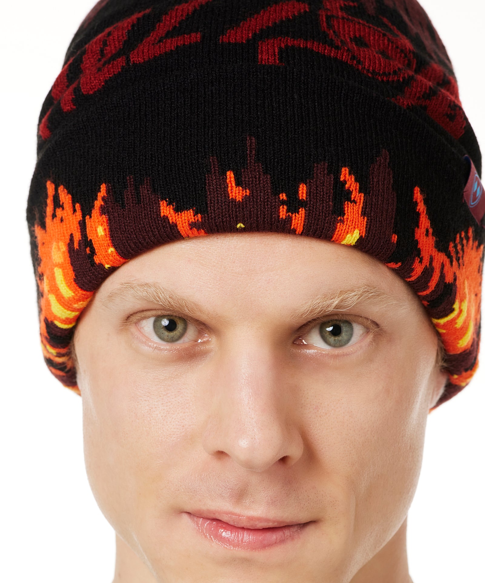 DETAIL OF A MALE MODEL WEARING A BEANIE HAT WITH FLAMES AND THE WORDS "TILL I DIE"