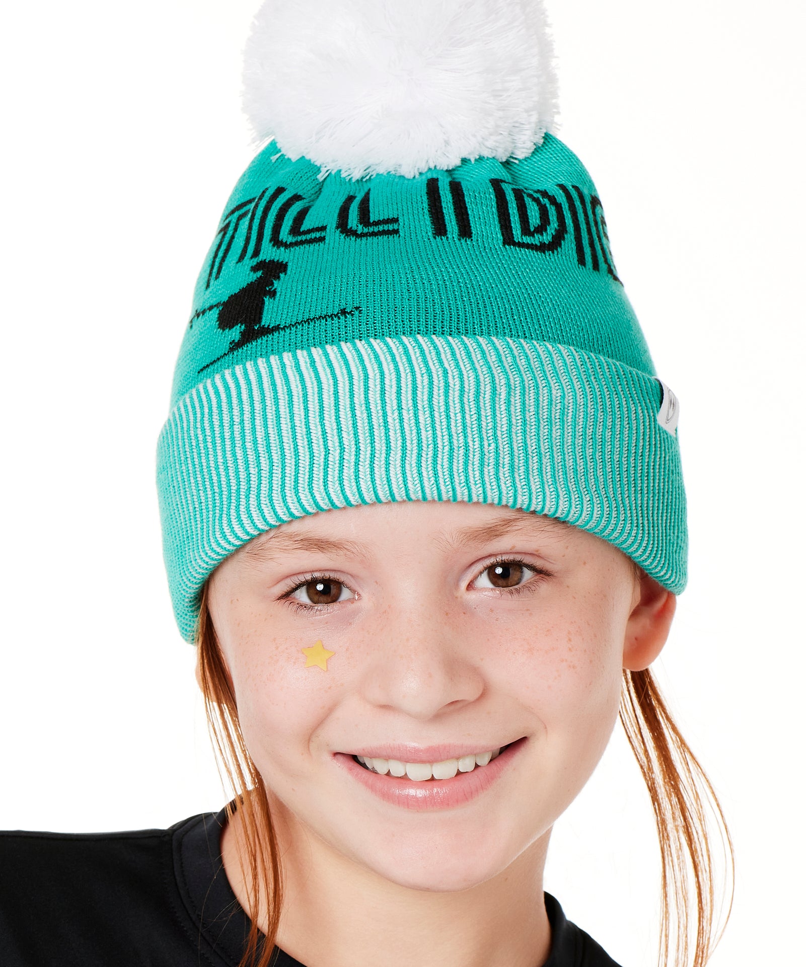 A YOUTH MODEL  WEARING A MINT GREEN BEANIE WITH A WHITE POM POM AND THE GRAPHIC OF A SKIER