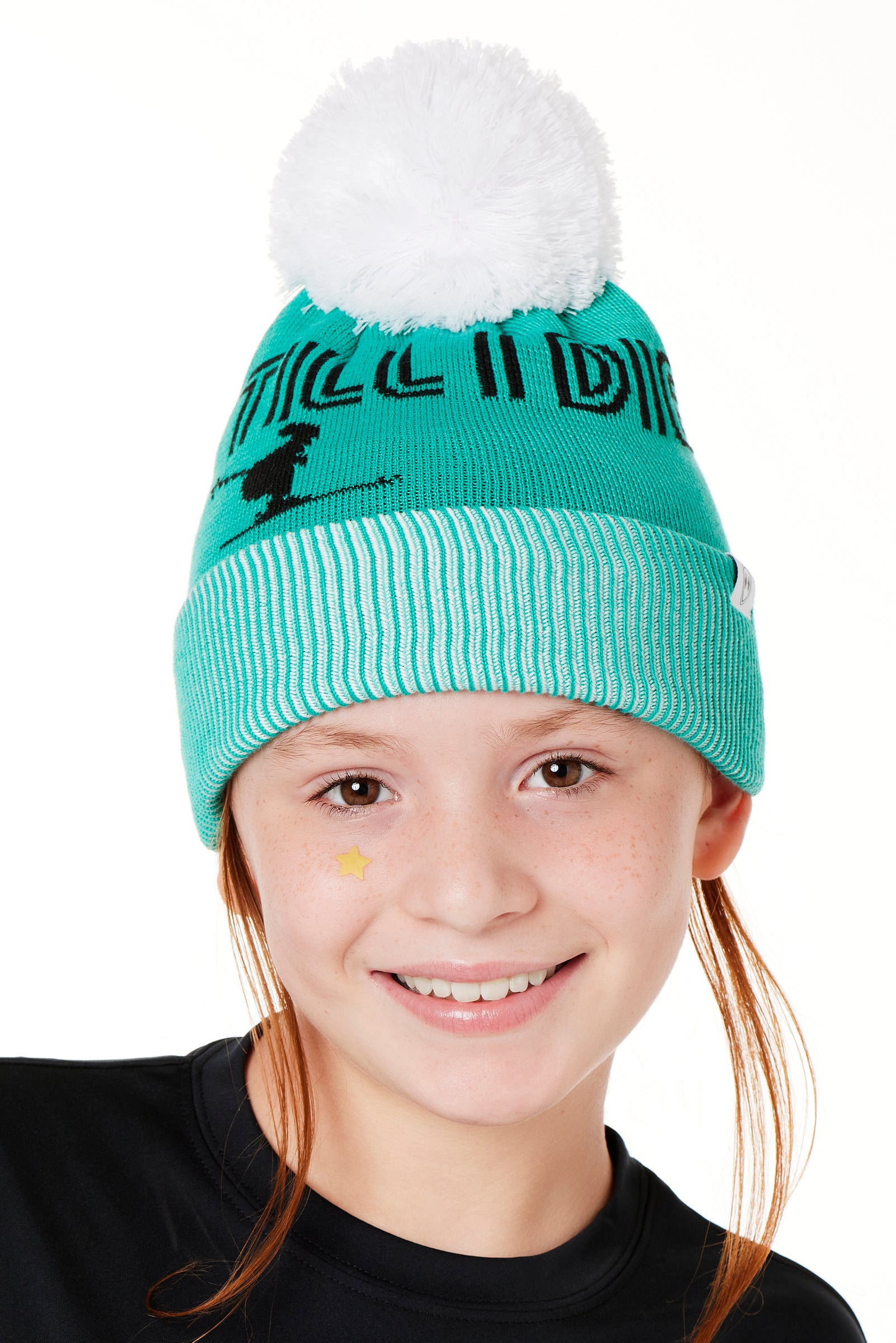 A YOUTH MODEL  WEARING A MINT GREEN BEANIE WITH A WHITE POM POM AND THE GRAPHIC OF A SKIER