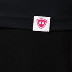 DETAIL OF A BLACK LONG SLEEVE BASE LAYER WITH THE TILL I DIE SHIELD LOGO WOVEN LABEL ON THE HEM