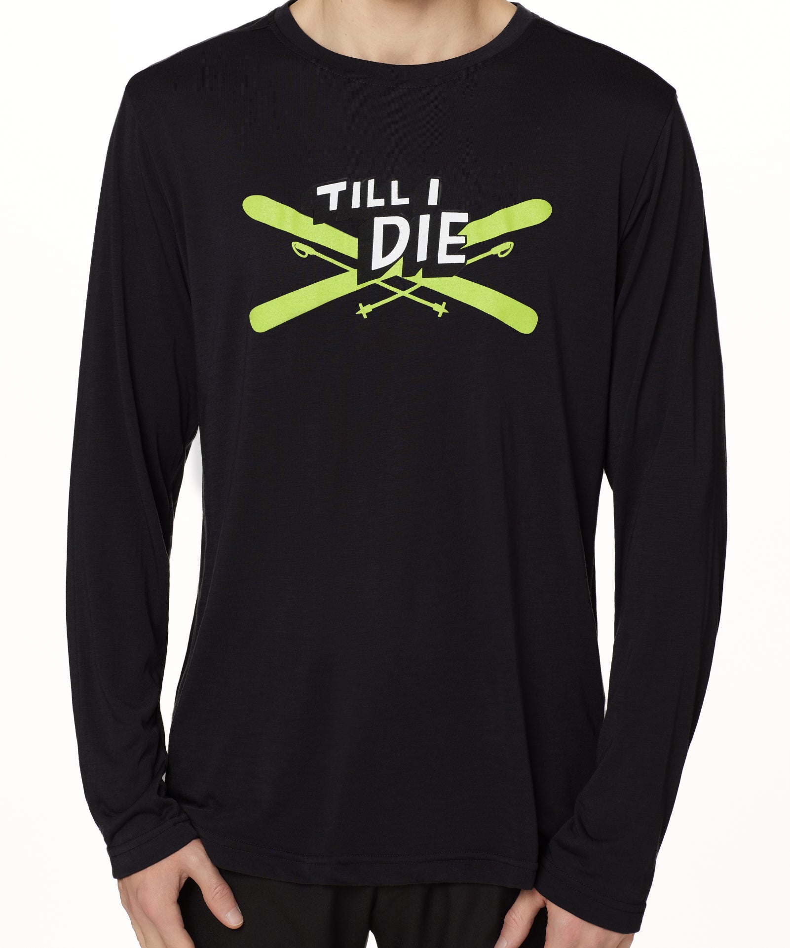 Front view of a male model wearing the Iron Cross long sleeve tee in black, displayed on a white background. The graphic features lime green crossed skis with poles, overlaid with bold black and white “Till I Die” text for a striking, alpine-inspired statement.