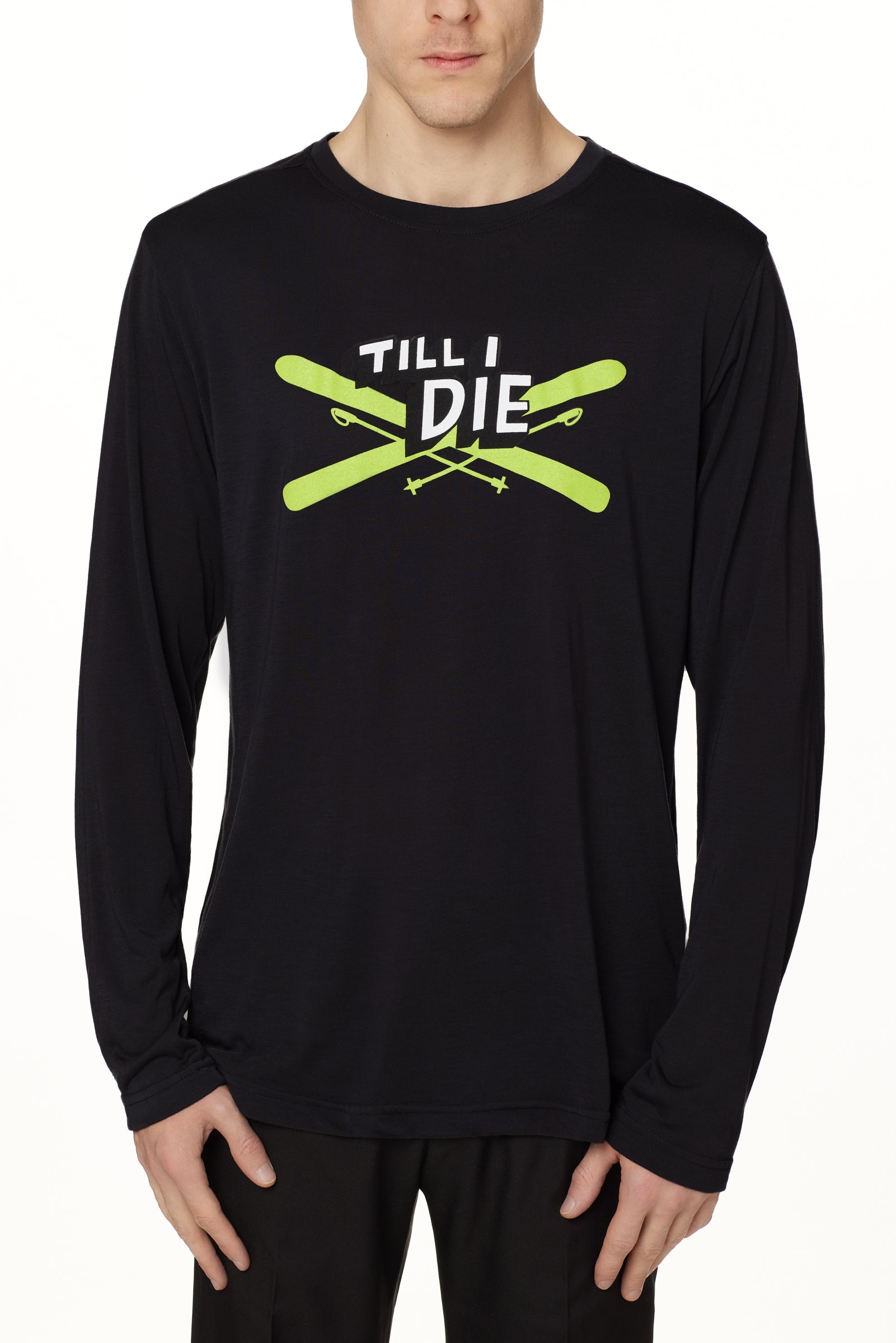 Front view of a male model wearing the Iron Cross long sleeve tee in black, displayed on a white background. The graphic features lime green crossed skis with poles, overlaid with bold black and white “Till I Die” text for a striking, alpine-inspired statement.