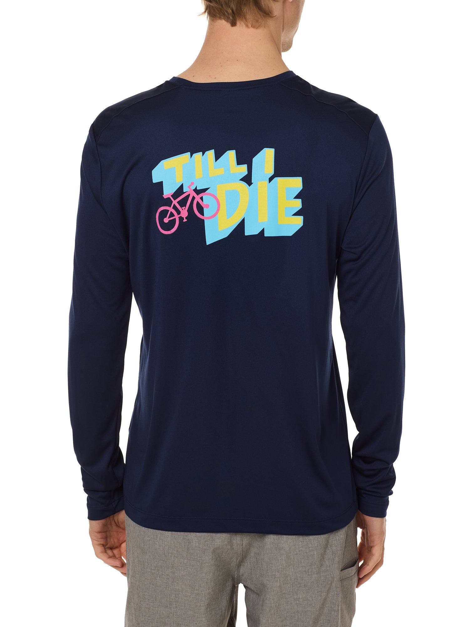 Back view of a male model wearing the Bike till i die performance long sleeve shirt in navy on a white background. The graphic features a pink mountain bike layered over bold blue and yellow till i die text