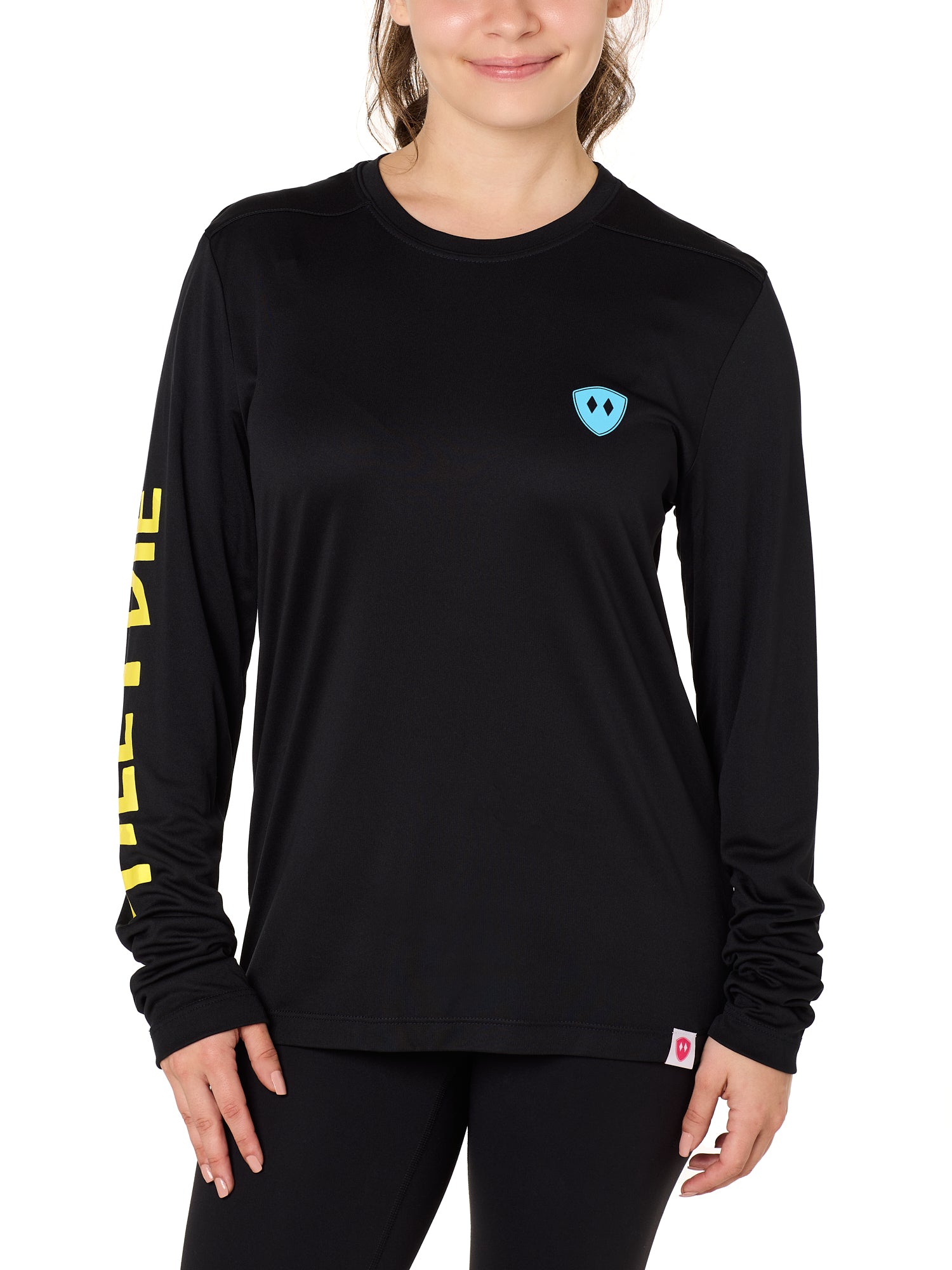 Front view of a female model wearing the Gear Head performance long sleeve tee in black on a white background. Accented with a cyan blue double diamond shield over wearers left chest.