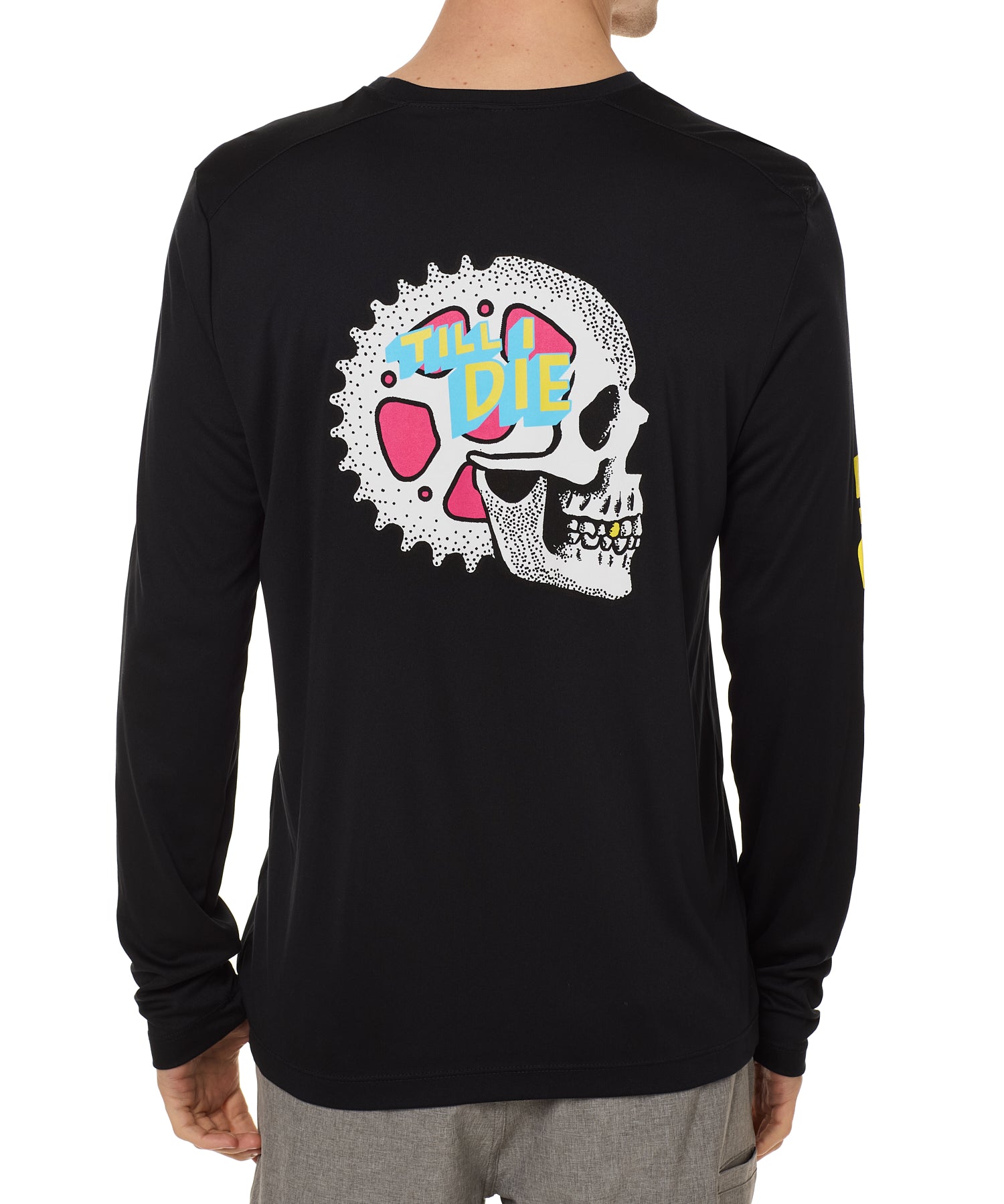 Back view of a male model wearing the Gear Head performance long sleeve Tee in black. The back graphic features a skull with gears inside the head and overlapped by yellow and blue "Till I Die" text.