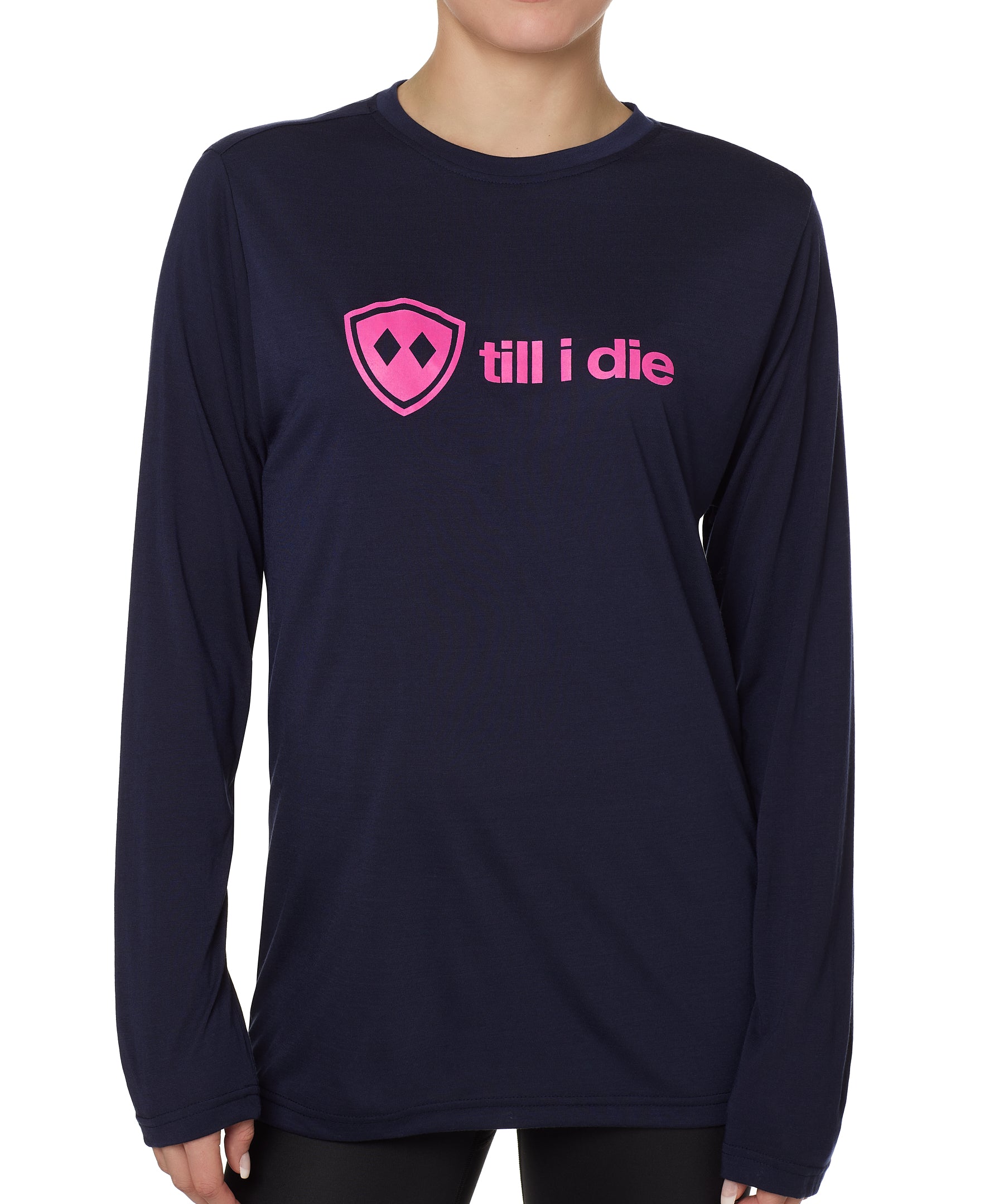 front view of a female model wearing a navy blue long sleeve tee with a hot pink till i die logo across the chest