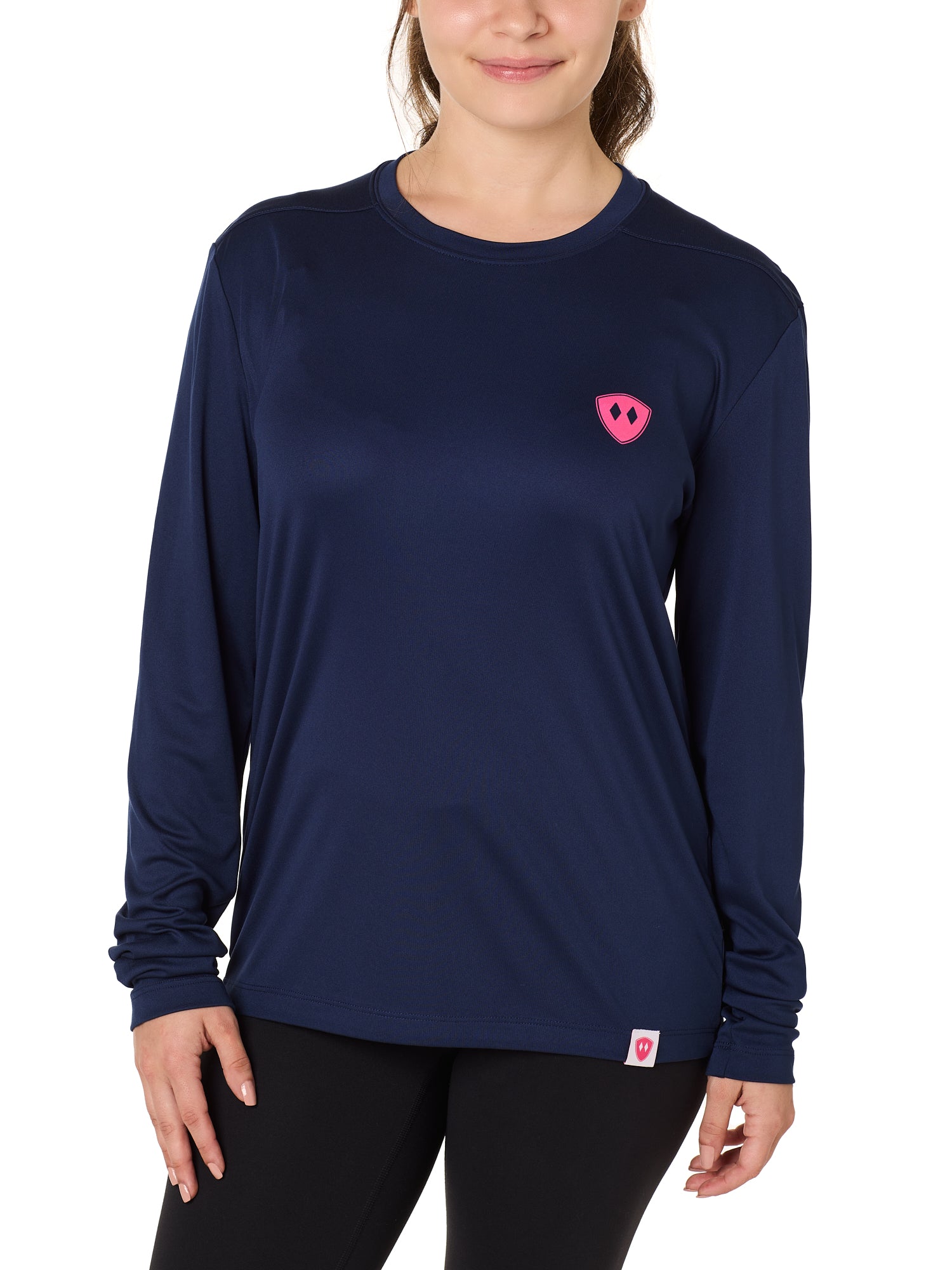 Front view of a female model wearing the Skull Wave Head performance long sleeve tee in Navy on a white background. Accented with a hot pink double diamond shield over wearers left chest.