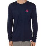 Front view of a male model wearing the Skull Wave Head performance long sleeve tee in Navy on a white background. Accented with a hot pink double diamond shield over wearers left chest.