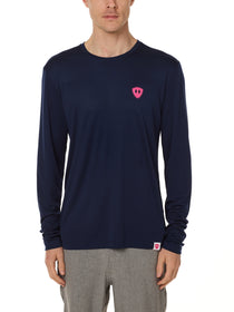 Front view of a male model wearing the Skull Wave Head performance long sleeve tee in Navy on a white background. Accented with a hot pink double diamond shield over wearers left chest.