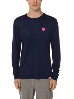 Front view of a male model wearing the Skull Wave Head performance long sleeve tee in Navy on a white background. Accented with a hot pink double diamond shield over wearers left chest.