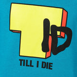 DETAIL OF A TEAL HOODIE FEATURING A BRIGHT YELLOW "T" WITH BLACK "I" AND "D", WITH TEXT BELOW IN BLACK SAYING "TILL I DIE"