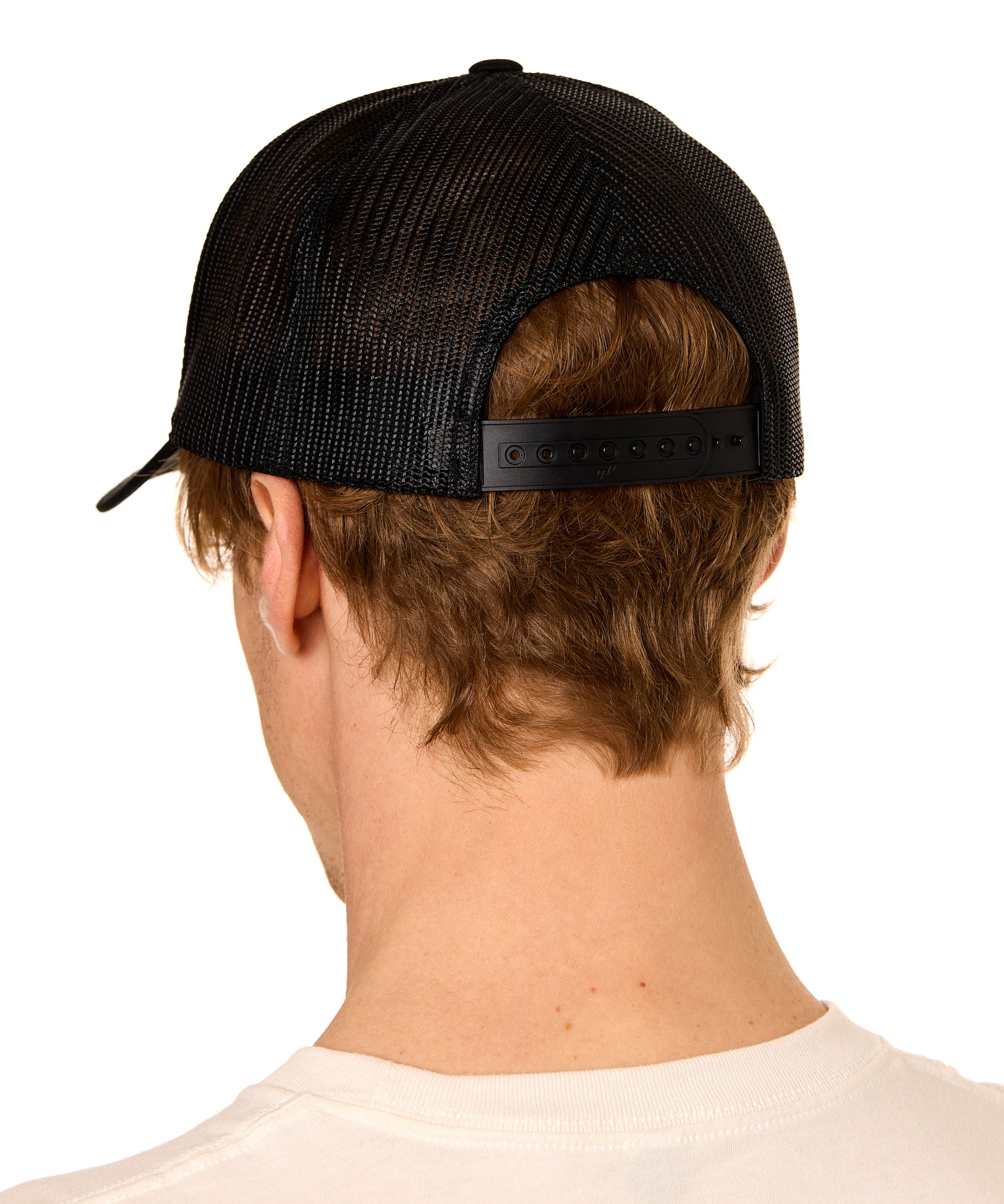 Back view of a male model wearing a classic white trucker hat featuring the mesh back panels and matching white snapback closure