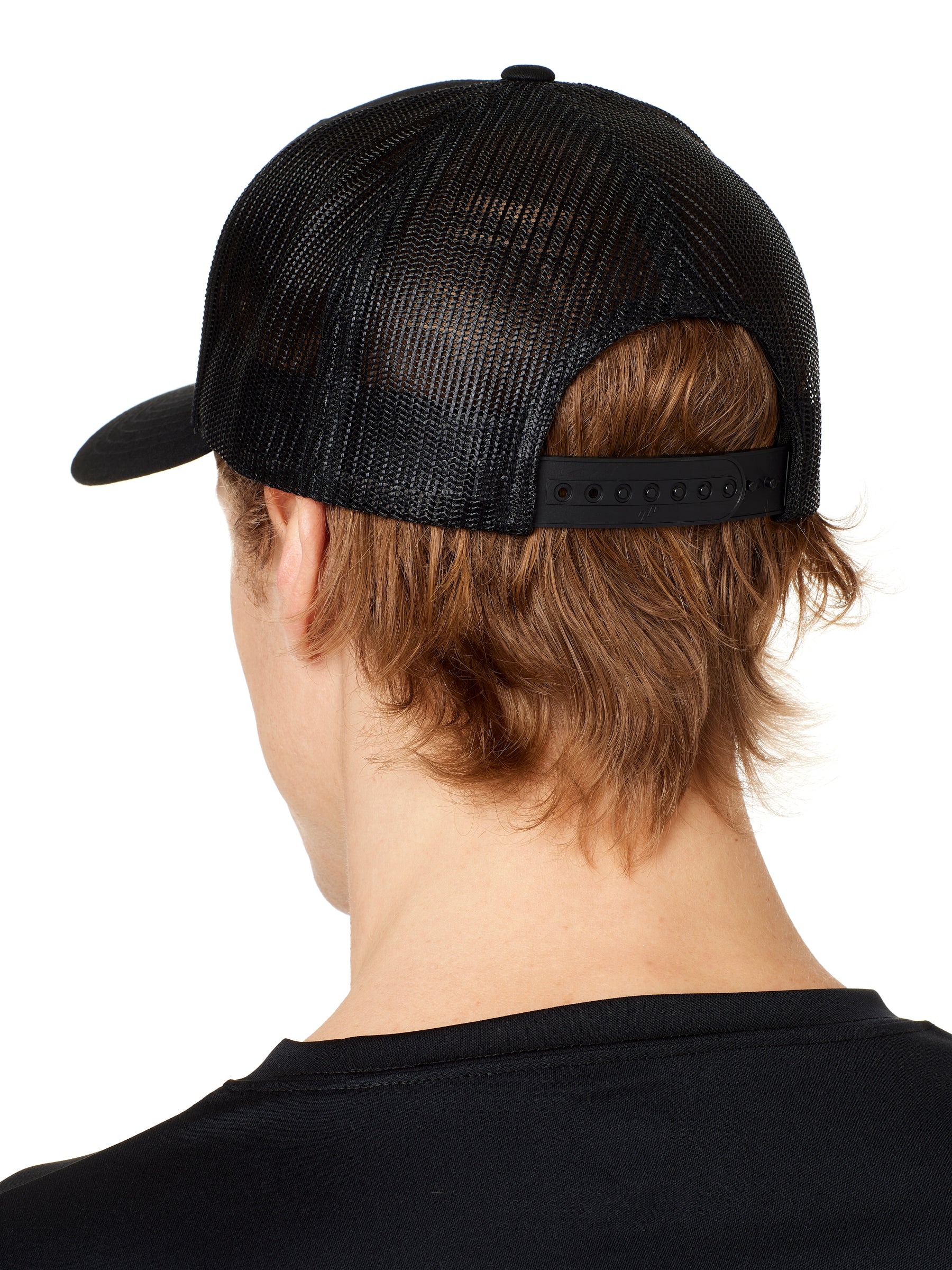 back view of a male model wearing a black classic trucker hat showing the mesh back panels and matching black snapback closure