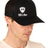 Front view of a male model wearing a black classic trucker hat, featuring a white embroidered Till I Die logo on the lower right front panel.