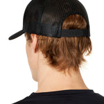 back view of a male model wearing a black classic trucker hat showing the mesh back panels and matching black snapback closure