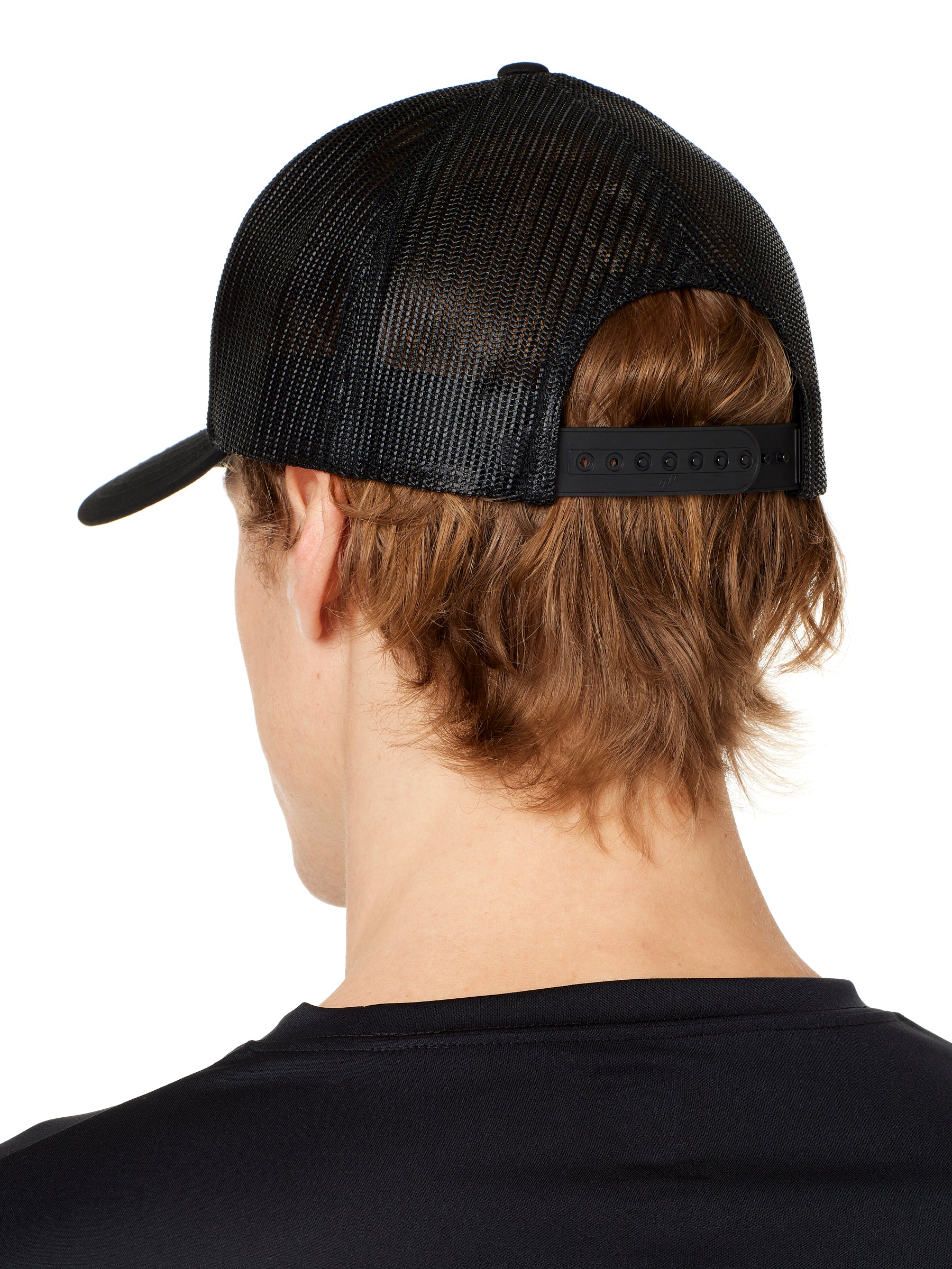 back view of a male model wearing a black classic trucker hat showing the mesh back panels and matching black snapback closure