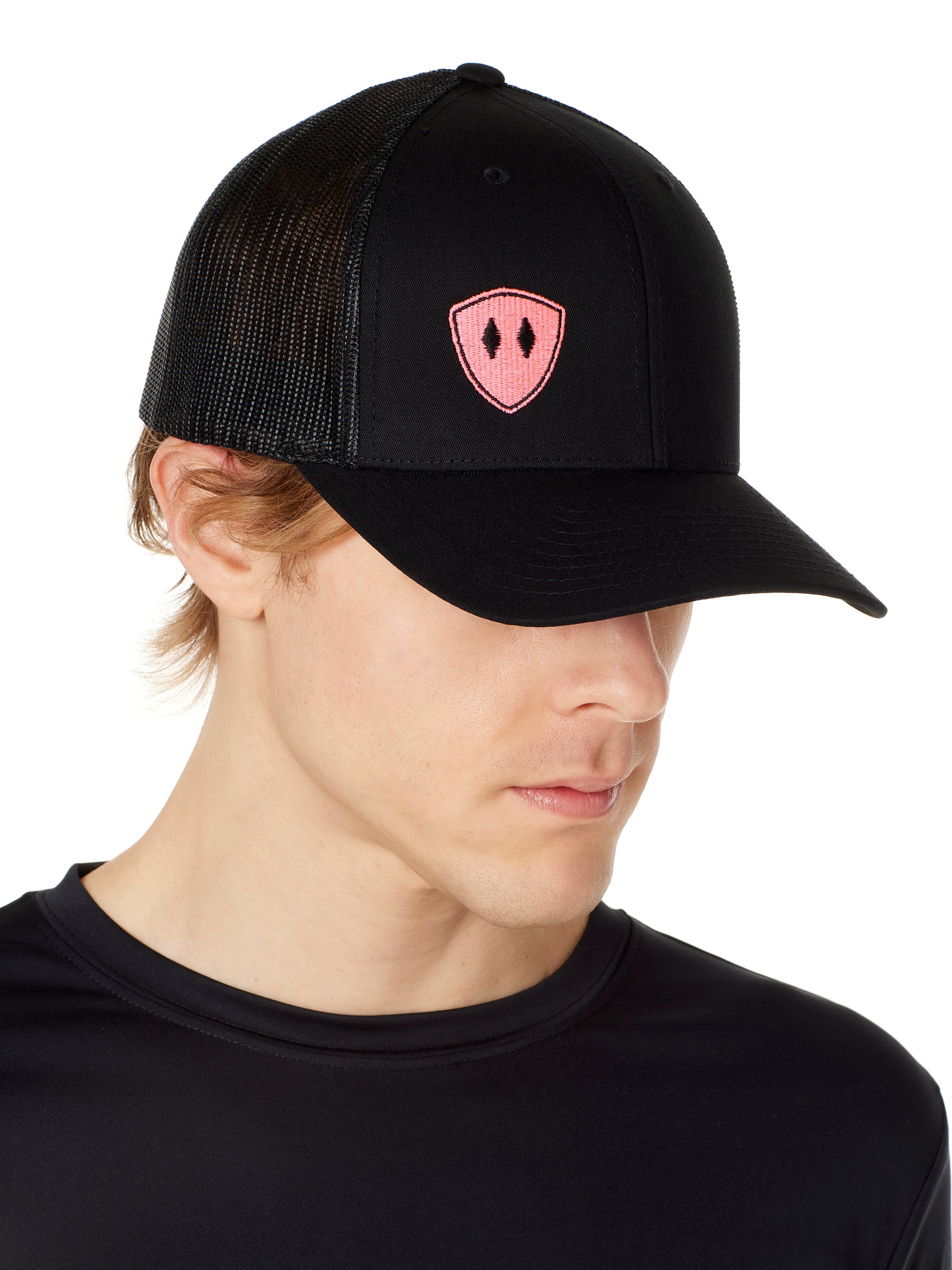 Front view of a male wearing a black classic trucker hat with a pink embroidered double diamond shield on the bottom right panel