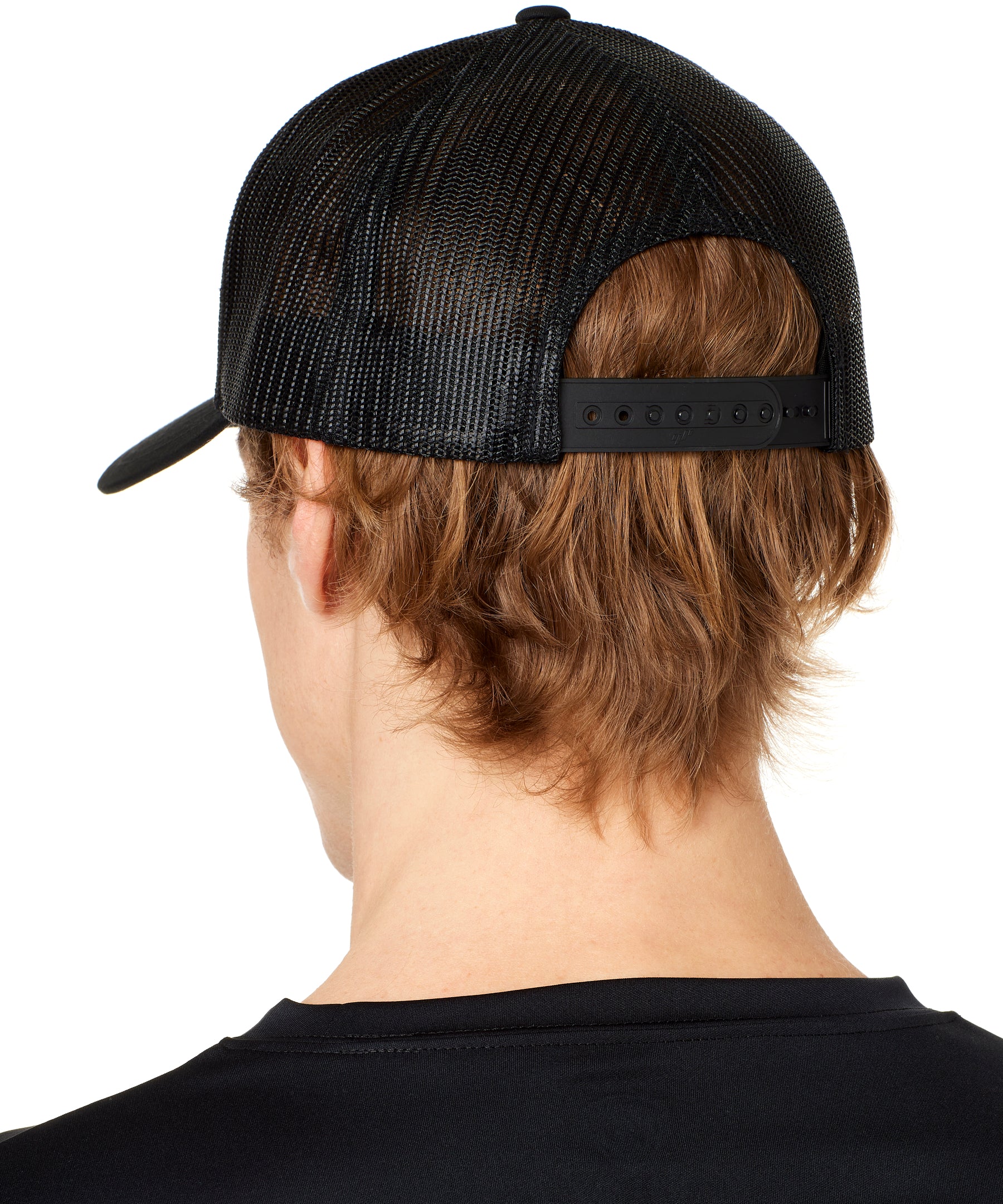 back view of a male model wearing a black classic trucker hat showing the mesh back panels and matching black snapback closure