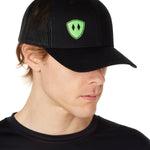 Front view of a male wearing a black classic trucker hat with a lime embroidered double diamond shield on the bottom right panel