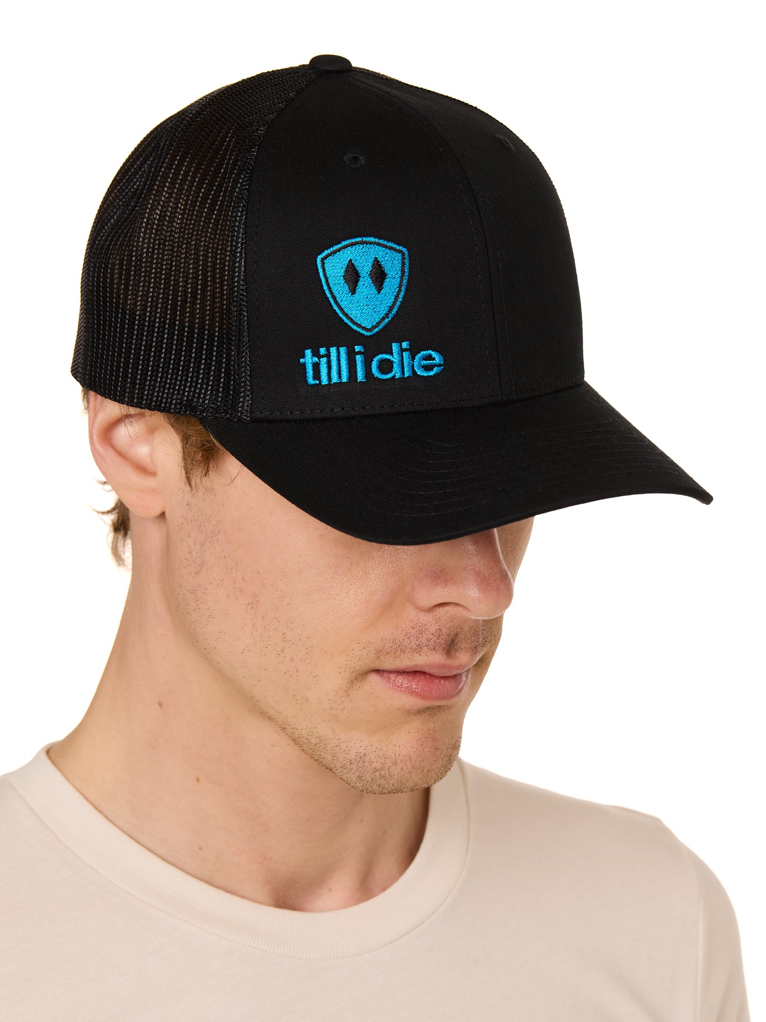 a man wearing a black trucker hat with blue till i die logo on a white background