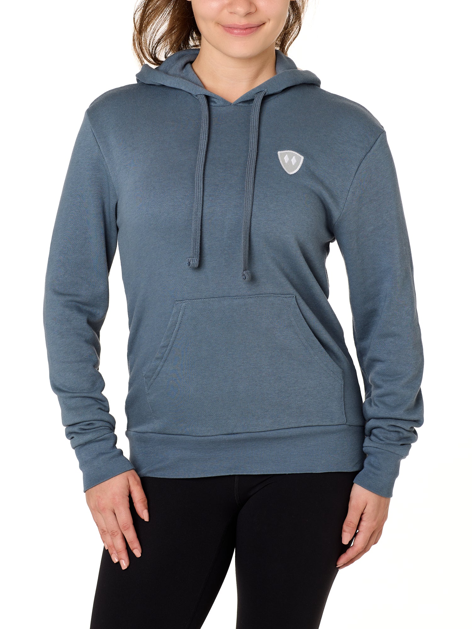 Front view of a female model wearing the Summer night hoodie in washed denim on a white background. The hoodie is embroider with a gray and white  double diamond shield over the wearers left chest.